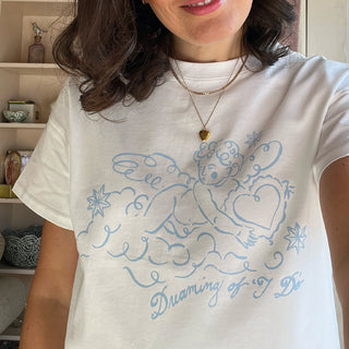 Person wearing a white t-shirt with blue cherub design