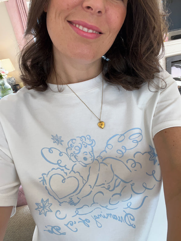 Charlotte Mills - Angel - White t-shirt with blue cherub graphic design and text that reads "dreaming of I 'do'"