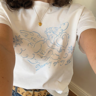 Person wearing a white t-shirt with blue cherub design