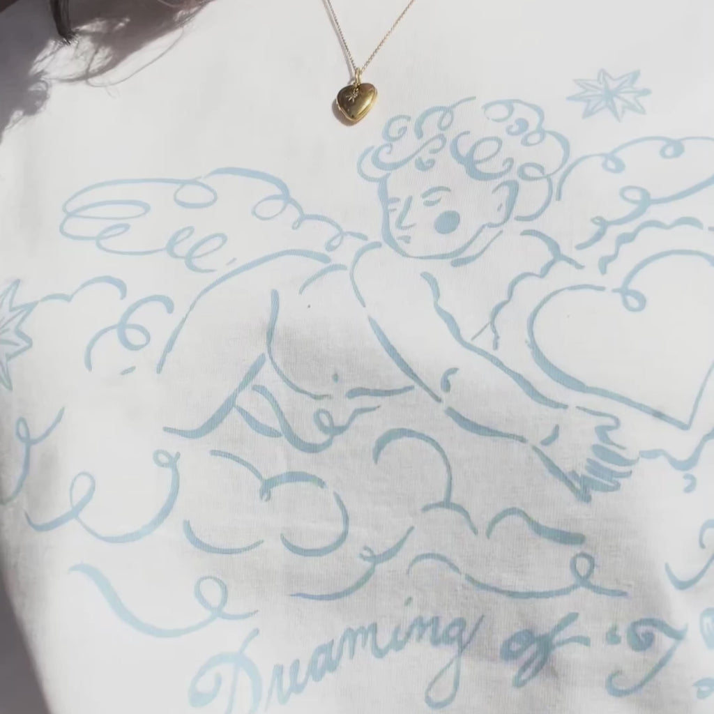 Person wearing a white t-shirt with blue cherub design